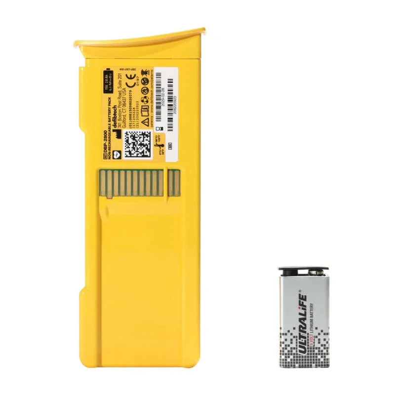 Yellow medical defibrillator battery pack next to silver Ultralife 9V lithium battery.